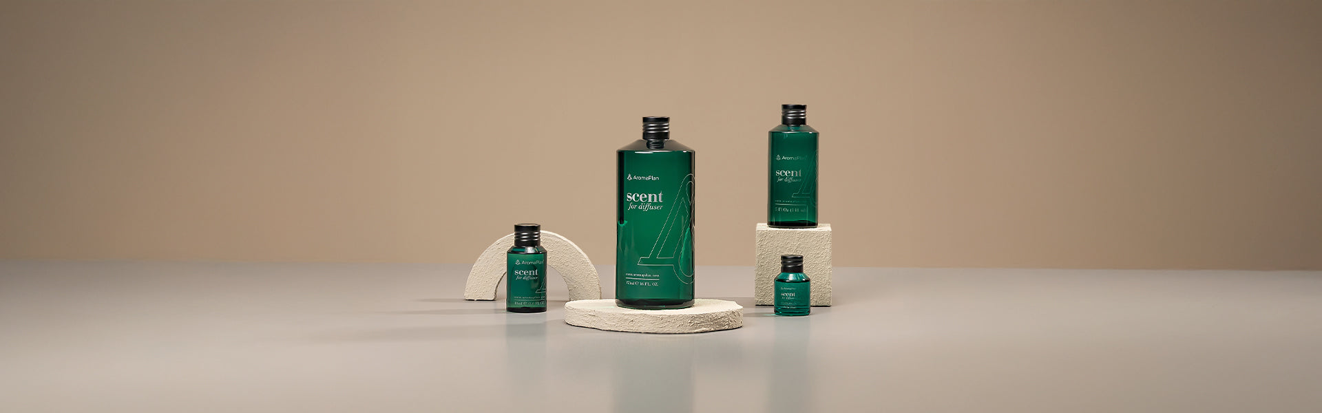 A selection of diffusers with different bottle shapes and elegant designs, arranged on a light grey surface with a neutral, beige backdrop.